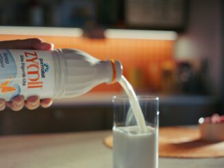 Bottiglia di latte senza lattosio Parmalat Zymil accanto a un bicchiere di latte e una ciotola di cereali in una cucina luminosa, con scritta 'Buongiorno Benessere'.