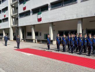 Cerimonia ufficiale della Guardia di Finanza con militari in uniforme schierati e tappeto rosso all'esterno di un edificio